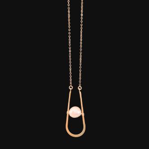 A minimalist necklace with a fine gold chain suspending a modern U-shaped wire pendant that cradles a single floating pinkish-white baroque pearl, isolated on a stark black background.
