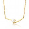 Minimalist gold curved bar necklace with a central white pearl on a reflective white background