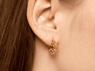 A pair of small, gold bubble-shaped stud earrings with a smooth, polished finish.