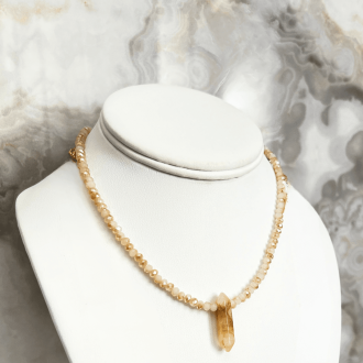 Short crystal point necklace on white bust.