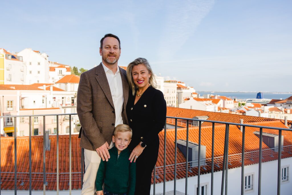 Family photos on a rooftop in Lisbon with a sun setting.