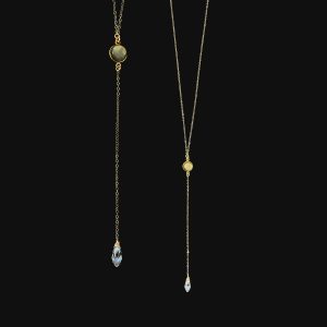 Handcrafted 14k gold-filled lariat necklace featuring a round bezel-set labradorite gemstone and a faceted clear crystal teardrop pendant against a black background.