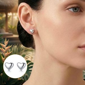 Woman wearing petite waterproof heart earrings on a tropical vacation