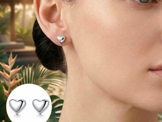 Woman wearing petite waterproof heart earrings on a tropical vacation