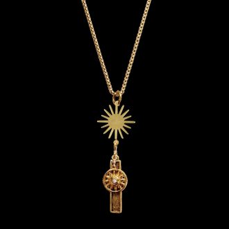 Gold pendant necklace with a sharp multi-ray sunburst charm dropping down to a celestial wheel charm inset with a tiny white crystal, ideal for resort jewelry collections.